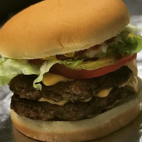 Double cheeseburger from Bama Boys BBQ with lettuce, tomato, pickles, and special sauce.