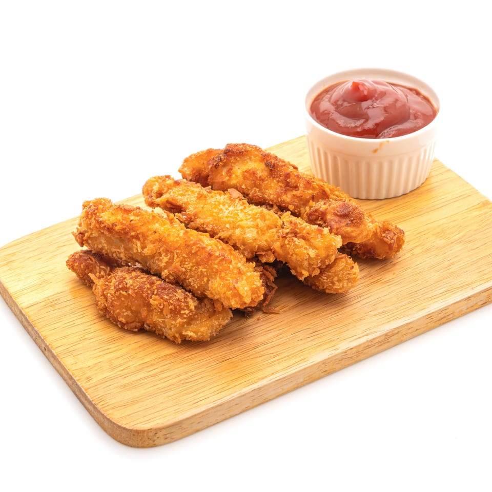 Crispy fried chicken tenders with a side of Bama Boys BBQ sauce on a wooden board.